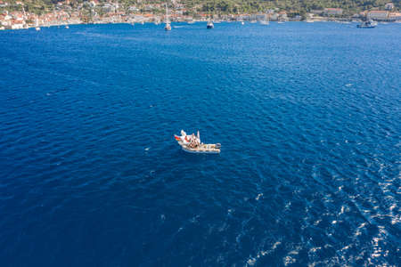 Vis, Croatia - Agu 18, 2020: Aerial drone shot tourists in inflatable speed boat in summerのeditorial素材