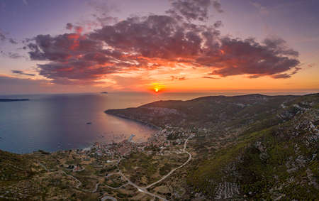 Aerial drone shot sunset over Adriatic horizon burning sky in Komiza port on Vis Island in Croatia summerの写真素材
