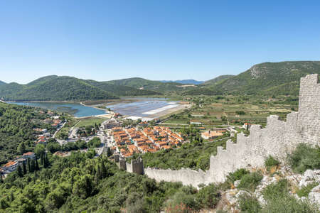 Stone wall of ston on hill with view of sault field in Dalmatia Croatia summerの写真素材