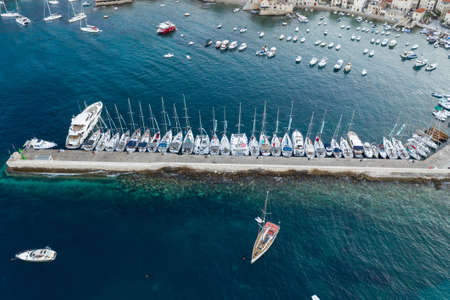 Komiza, Croatia - Aug 19, 2020: Aerial drone shot dock by Komiza on Vis Island before sunrise in summerのeditorial素材