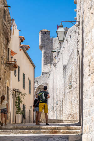 Tourists walk in stone passage by City Wall in Dubrovnik in Croatia summerのeditorial素材