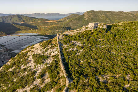 Aerial drone shot of City Wall of Ston over hill to Mali Ston in Croatia summer morning sunriseの写真素材