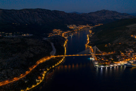 Aerial drone shot of Port Gruz by Dubrovnik bridge with lights in Croatia summer at dusk