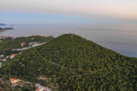 Aerial drone shot of radio tower on top of Petka hill by sunset beach in Dubrovnik after sunset in...