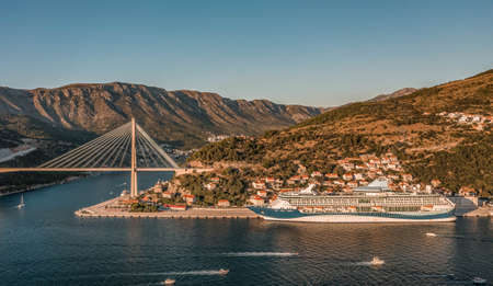 Aerial drone shot of Dubrovnik bridge and cruise at port in Dalmatia in Croatia sunsetの写真素材