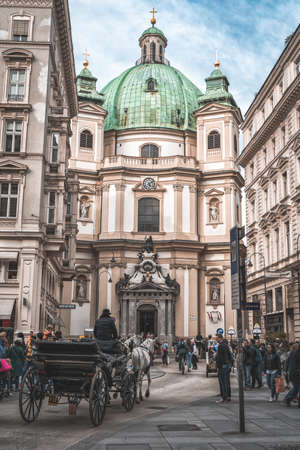 Vienna, Austria - April 27, 2019: Horse carriage pass by Baroque Peterskirche, St. Peters Parish Churchのeditorial素材