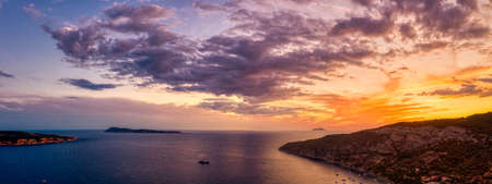 Aerial panoramic drone shot of burning sky sunset clouds on Adriatic horizon from Komiza on Vis Island in Croatia summerの写真素材