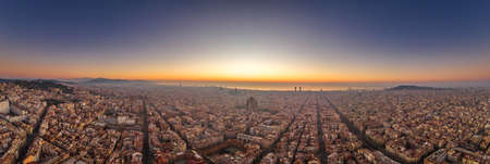 Aerial panorama drone shot of Barcelona with sunrise over sea horizon in Spain winter dawnの写真素材