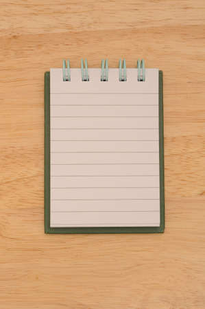 Note pad isolated on wooden surfaceの写真素材