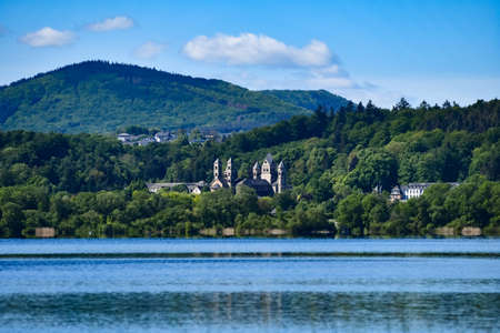 The Benedictine monastery in Maria Laach with the Laacher See on a beautiful spring dayの写真素材