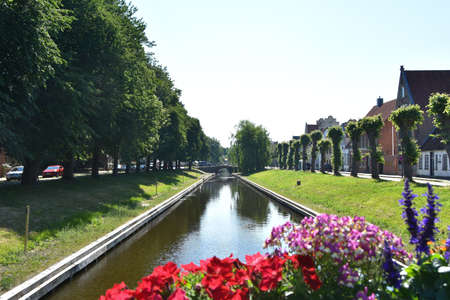 FRIEDRICHSTADT, GERMANY June 26, 2020 Beautiful flowers with a canal from Friedrichstadtのeditorial素材
