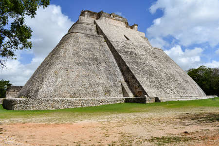 The pyramid of Uxmal with a blue sky and cloudsの写真素材
