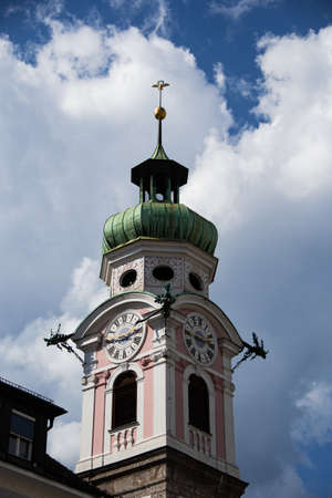 Church tower of the Spitalkirche in Innsbruck with blue sky and cloudsの写真素材