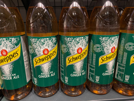 Several bottles of Schweppes with the flavor American Ginger Ale on the shelf of a German...