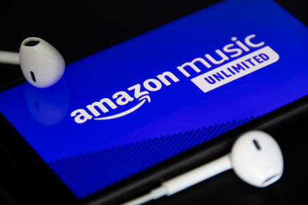 Rheinbach, Germany 4 May 2021, Close-up of the "Amazon music unlimited" logo on the screen of a smartphone with headphonesのeditorial素材