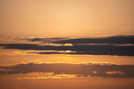 Sunset over the sea. The sun sets behind the clouds.
