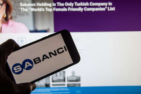Rheinbach, Germany 2 February 2022, The brand logo of the Turkish company "SabancÄ± Holding" on the display of a smartphone in front of the website (focus on brand logo)のeditorial素材