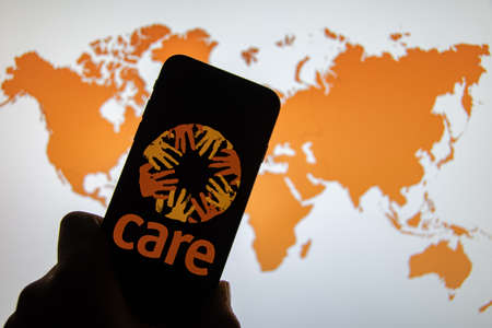 Rheinbach, Germany 1 April 2022, The brand logo of the aid organization "Care International" on the display of a smartphone (focus on the brand logo)のeditorial素材