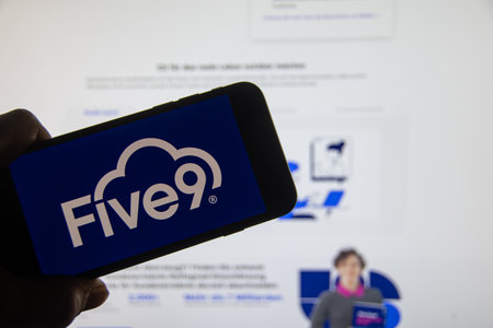 Rheinbach, Germany 13 March 2024, The brand logo "Five9" on the display of a smartphone in front of the website (focus on the brand logo)のeditorial素材