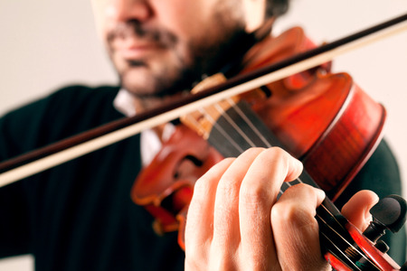 Musician playing violin in white backgroundの写真素材
