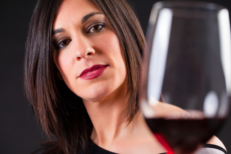 Woman looking at wine, during wine marriage process.の写真素材