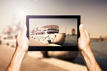 Taking photo with a tablet. Luxury yacht on the scene.の写真素材