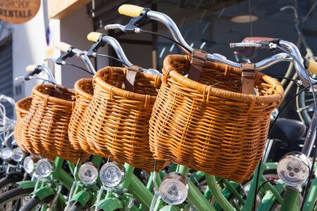Vintage bikes with baskets parked in row in the street.の写真素材