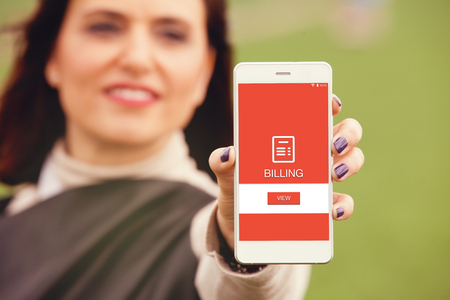 Billing information in a mobile phone. Woman holding smartphone with billing app.の写真素材