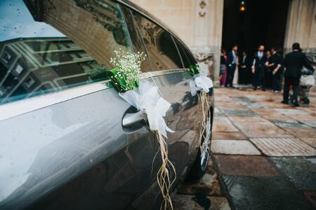 Wedding car detail with people and a church in the background.の写真素材