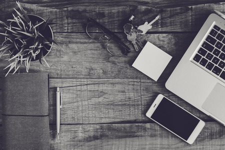 Top view of business and electronics stuff on a wooden desk. Black and white.の写真素材