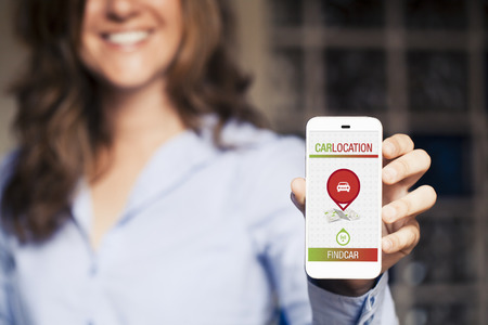 Locating car app in a mobile phone. Woman holding it in the hand.の写真素材