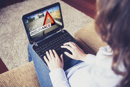 Woman searching for car insurance on the internet with a laptopの写真素材