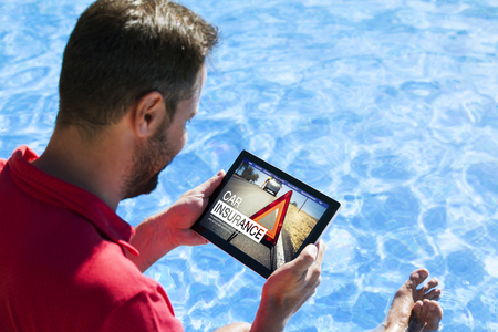 Man researching car insurance on the internet with a tablet.の写真素材