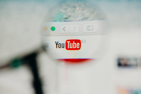 MALAGA, SPAIN - JUNE 3, 2017: Youtube website detail in a computer screen, viewed through magnifying glass. Social media video concept.のeditorial素材