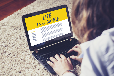 Life Insurance concept: Woman typing in a laptop computer with Life Insurance contract in the screen.の写真素材