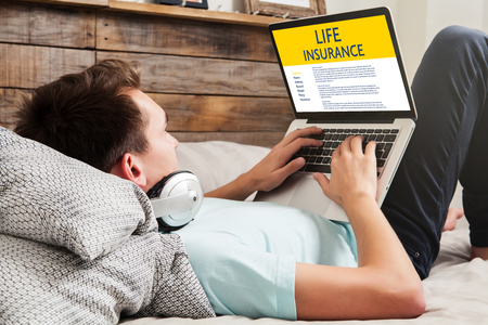 Life Insurance concept: Man typing in a laptop computer with Life Insurance contract in the screen.の写真素材