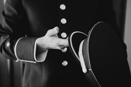 Man in uniform holding a cap. Black and white