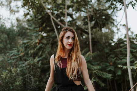 Blonde woman posing in nature, with the forest in the backgroundの写真素材
