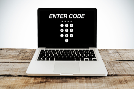 ENTER CODE access in a laptop screen, over wooden deskの写真素材