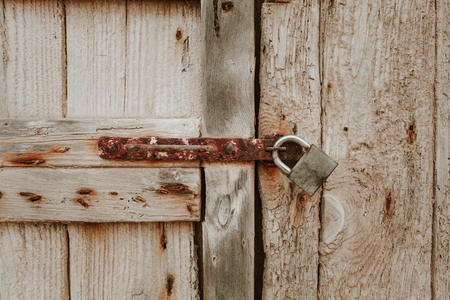 Ancient wooden closed door detail with a padlock.の写真素材
