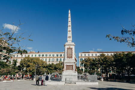 MALAGA, SPAIN - DECEMBER 5th, 2017: Merced Square and monolith in the centre, and people walking around it, on December 5th, 2017 in Malaga, Spain.のeditorial素材