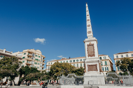 MALAGA, SPAIN - DECEMBER 5th, 2017: Merced Square and monolith in the centre, and people walking around it, on December 5th, 2017 in Malaga, Spain.のeditorial素材