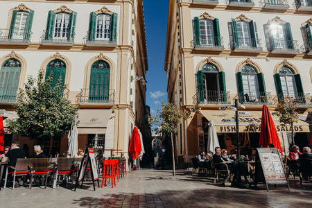 MALAGA, SPAIN - DECEMBER 5th, 2017: Tourists sitting in a terrace bar having a drink on the popular Merced Square in the city center of Malaga, Spain, on December 5th, 2017.のeditorial素材