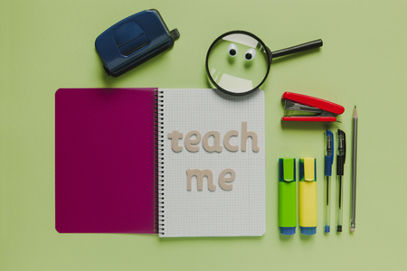 School concept with "Teach me" lettering made with wood, on a notebook.の写真素材