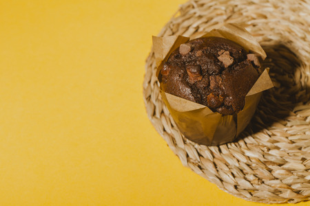 Chocolate muffin on a mat with yellow background.の写真素材