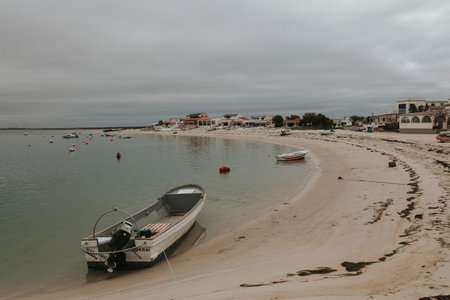 Armona Island, Portugal - March 23, 2018: Little boats docked in the Armona island beach in a cloudy...