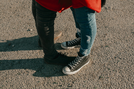 Cool couple legs and feet in sneakers while embracing on the city asphalt.の写真素材