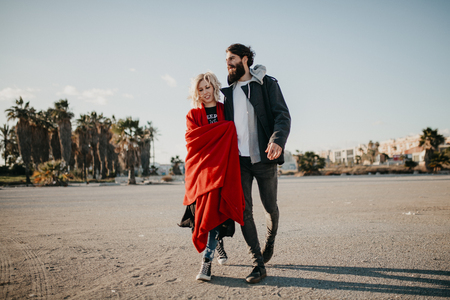 Cool couple walking together outdoors in the city suburbs.の写真素材