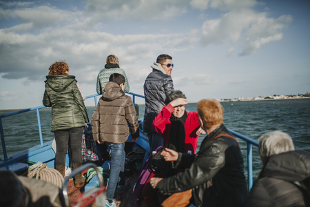 MARCH 24th, 2018 - OLHAO, PORTUGAL: Passengers enjoying the trip by boat between the portuguese city of OlhÃ£o and the Armona Island, navigating Ria Formosa under a beautiful blue sky, on March 24th, 2018.のeditorial素材