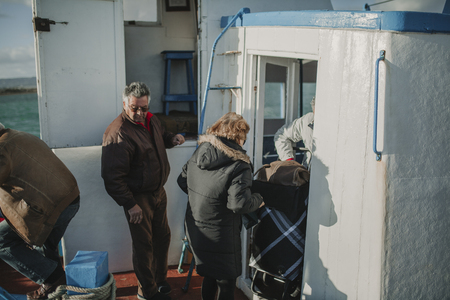 MARCH 24th, 2018 - OLHAO, PORTUGAL: People getting down from a boat and arriving to Armona Island, in Portugal, after the trip navigating Ria Formosa from OlhÃ£o city, on March 24th, 2018.のeditorial素材
